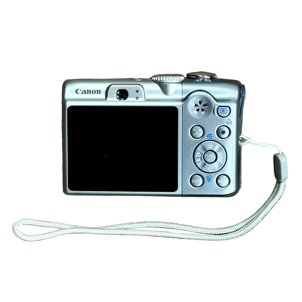 Canon PowerShot A1100 IS 12.1 MP Digital Camera w/ Case - Silver Canon digital camera with a strap on a white background