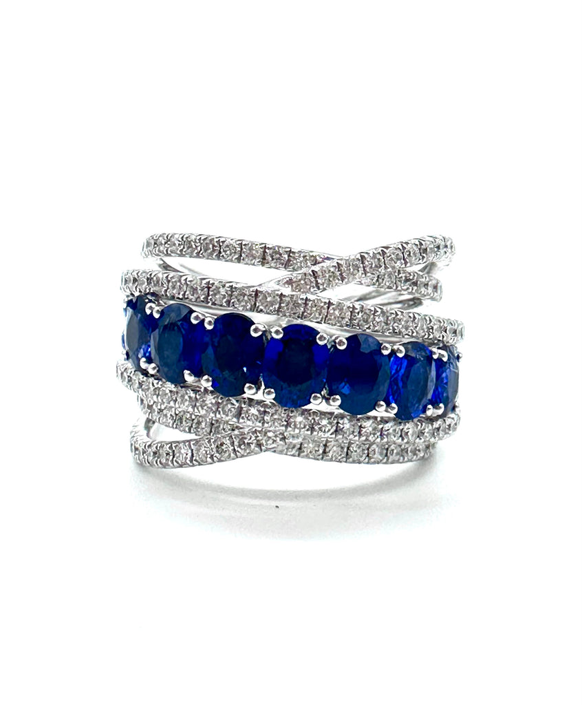 Multi-layered ring with blue gemstones and diamonds on a white background