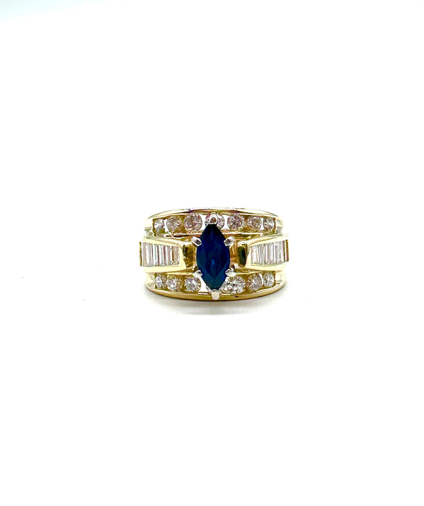 Gold ring with a blue gemstone and diamond accents on a white background