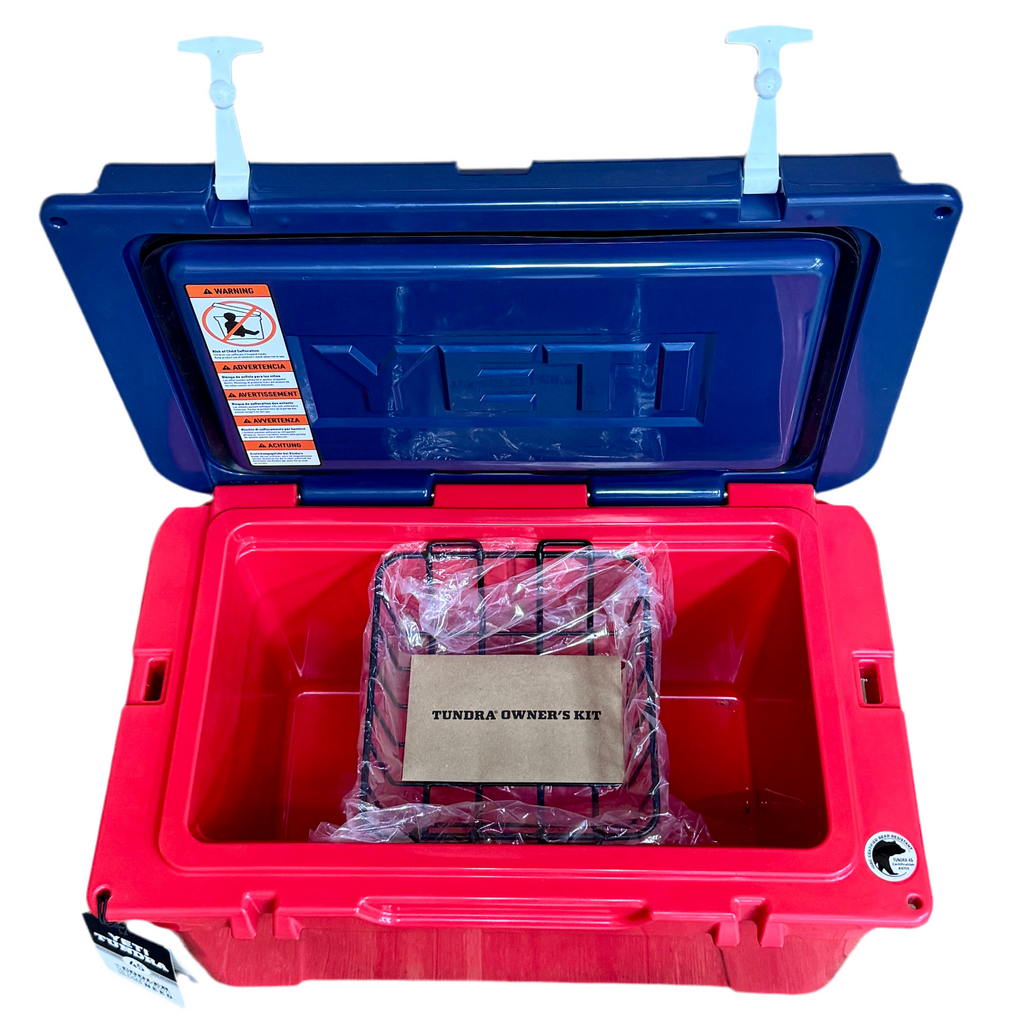 YETI Tundra 45 Hard Cooler - Limited Edition Red, White, & Blue 2024 Red and blue cooler with a TUNDRA owner's kit inside on a white background