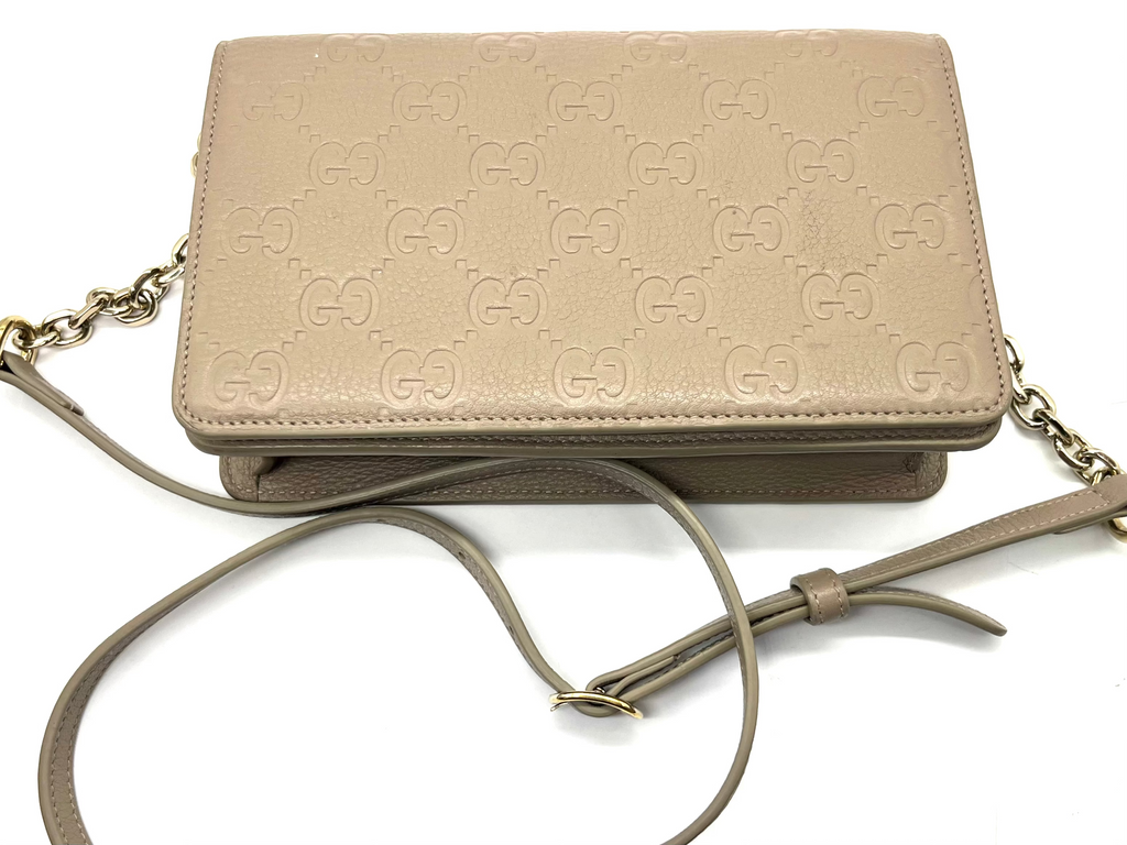 Beige handbag with chain strap on a white background