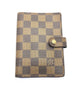 Checkered patterned wallet with a gold button on a white background