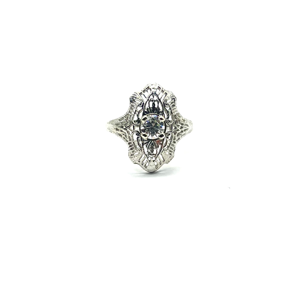 Silver ring with intricate design on a white background