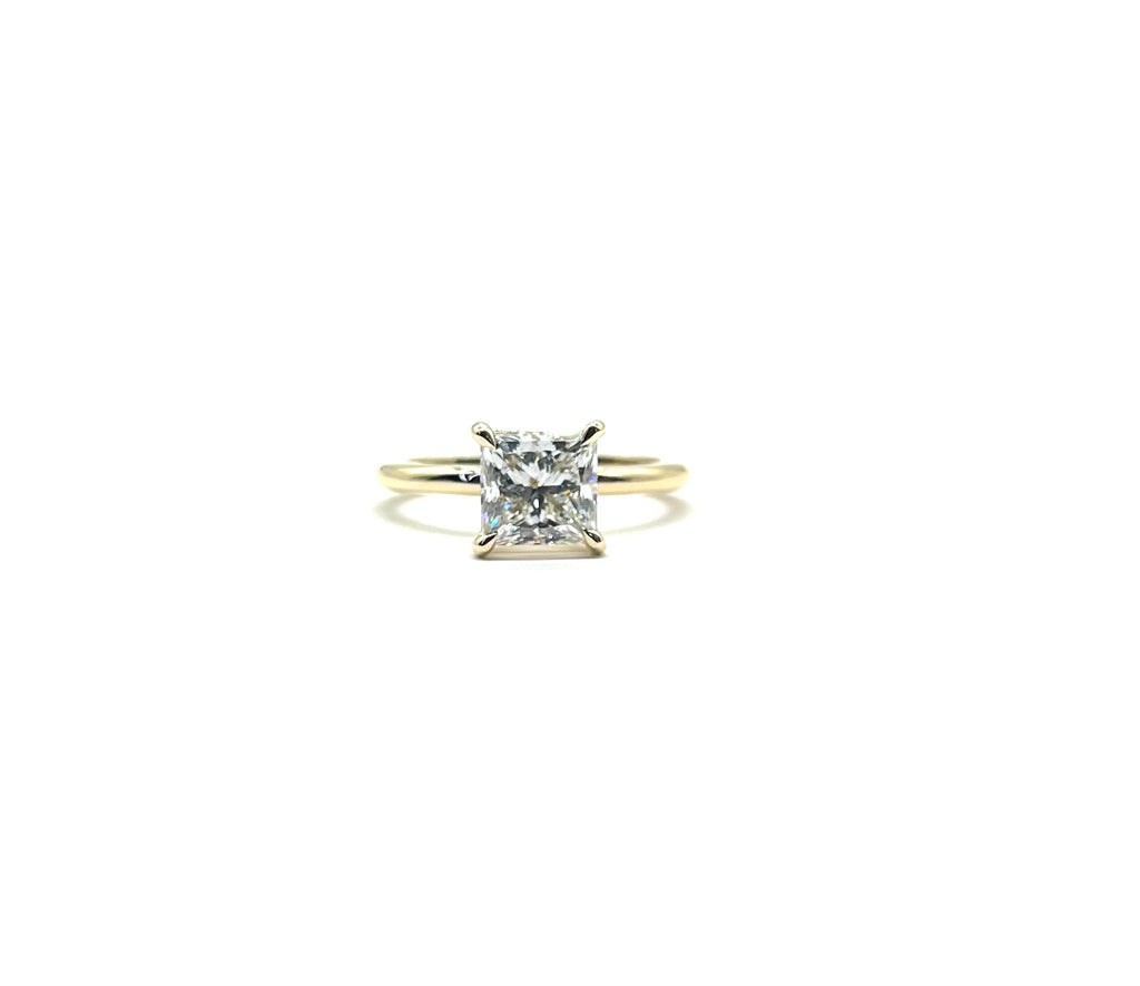 Gold ring with a diamond on a white background