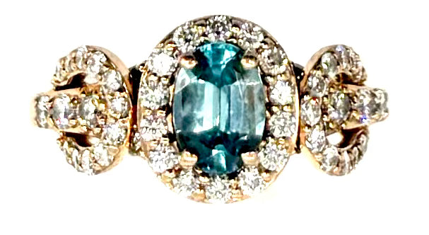 Ring with a blue gemstone and diamond accents on a white background