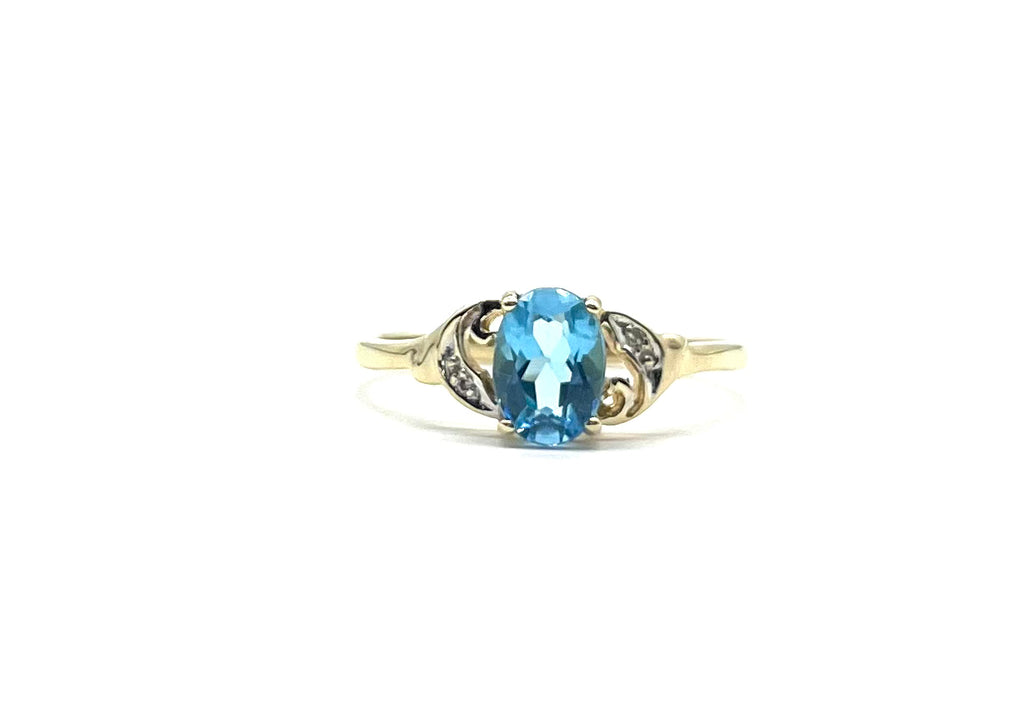 Gold ring with a blue gemstone on a white background