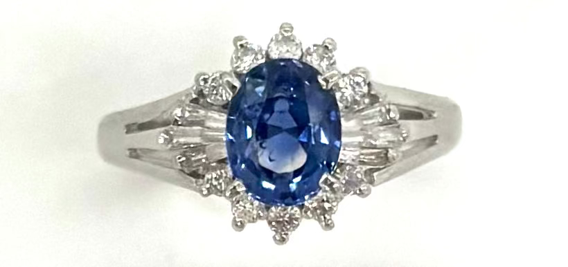 Ring with a blue gemstone and diamond accents on a white background