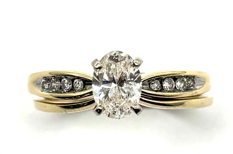 Gold ring with a large diamond and smaller diamonds on a white background