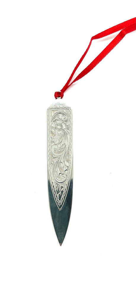 Decorative knife with intricate carvings on a white background