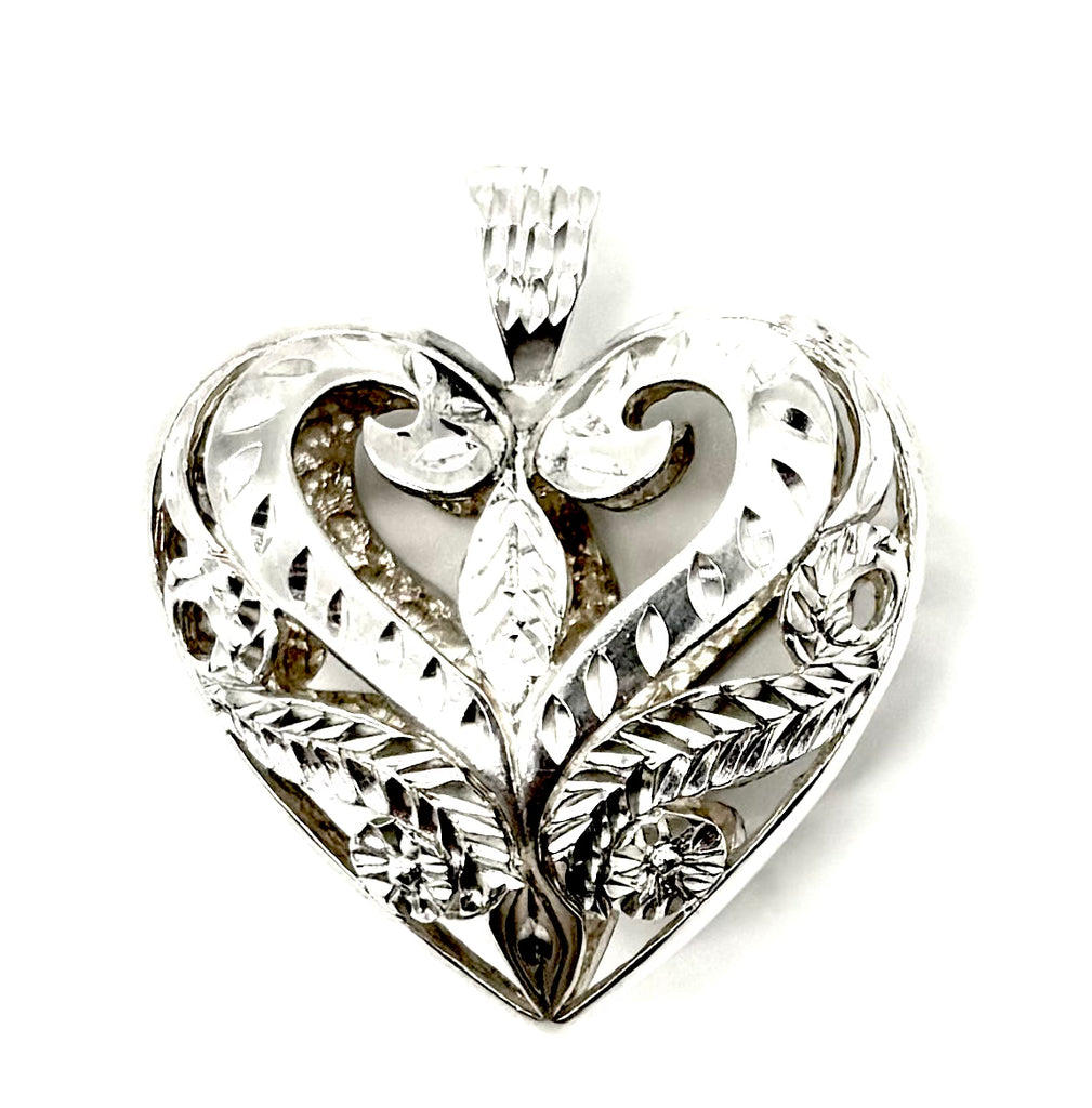 Silver heart-shaped pendant with intricate designs on a white background