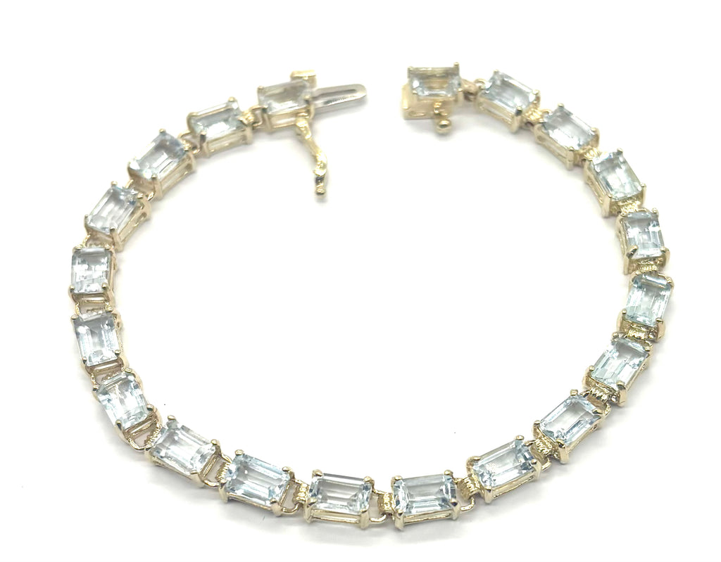 Gold bracelet with clear gemstones on a white background
