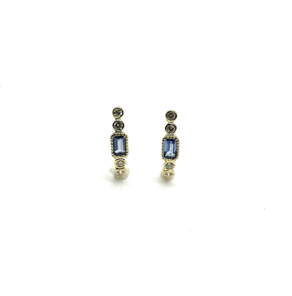 Pair of earrings with blue gemstones and gold accents on a white background