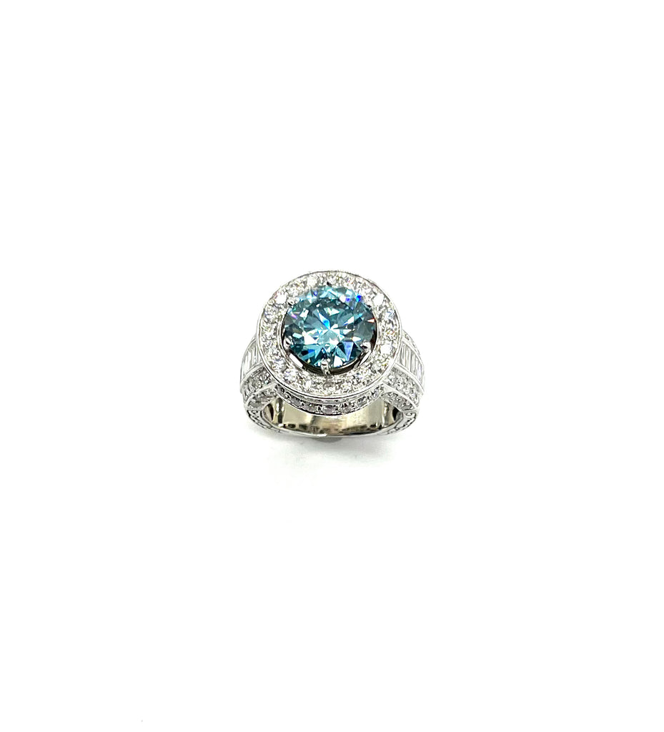 Ring with a blue gemstone and diamond-studded band on a white background