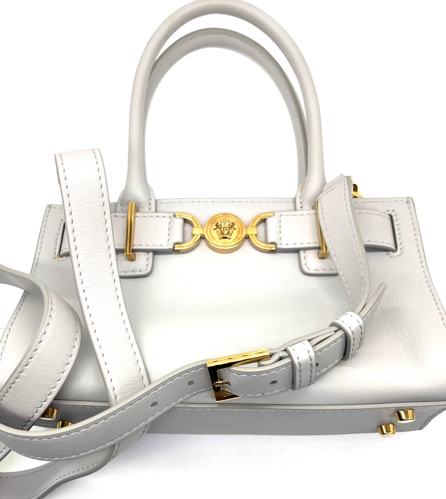White handbag with gold accents on a white background