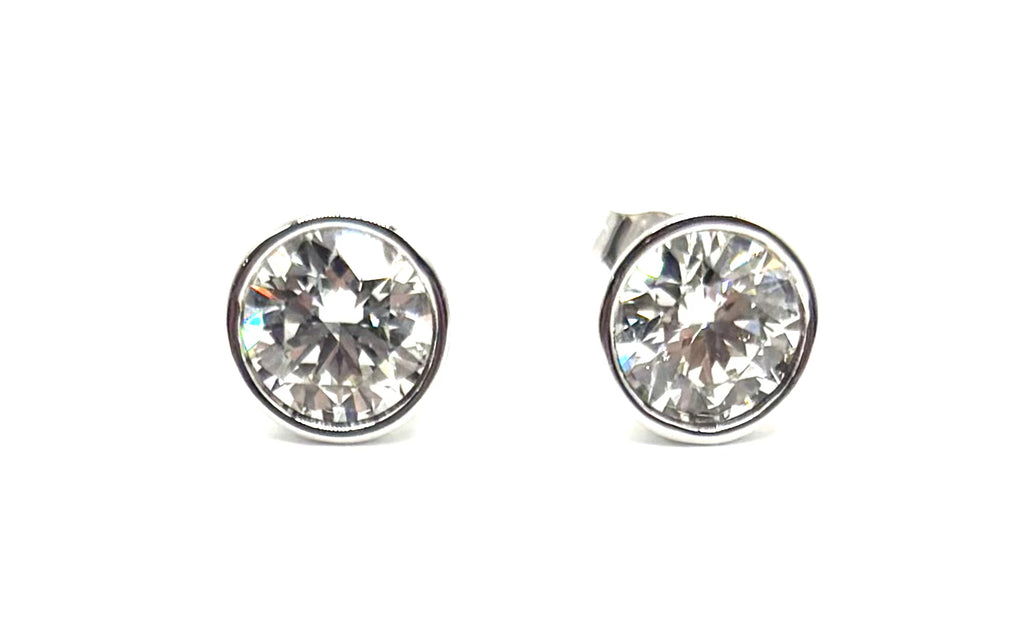 Pair of silver stud earrings with clear gemstones on a white background