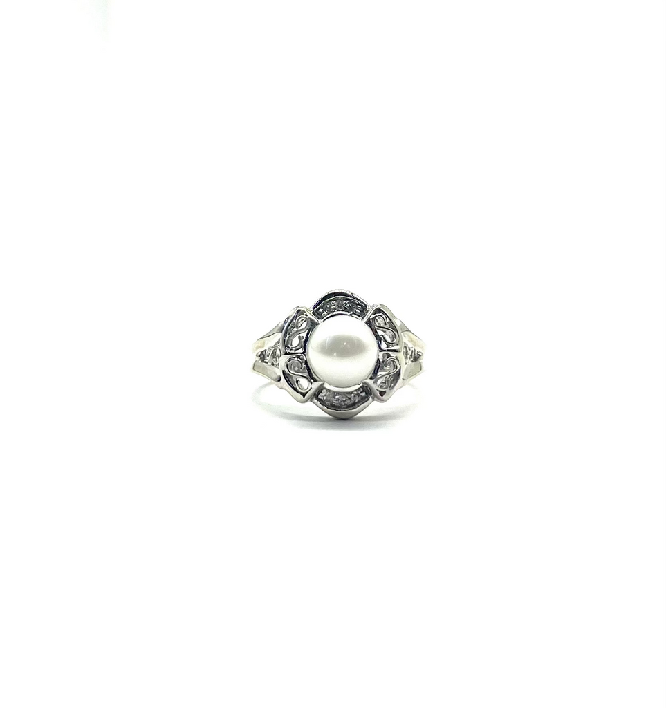 Silver ring with a pearl and small diamonds on a white background