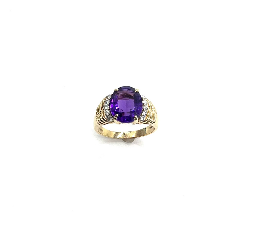 Gold ring with a purple gemstone on a white background