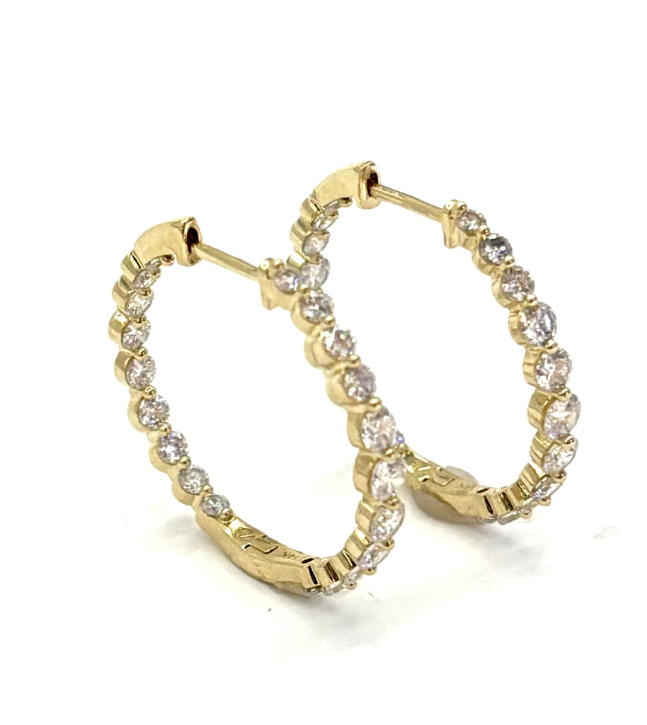 Gold hoop earrings with diamond accents on a white background