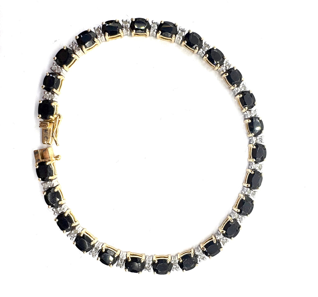 Bracelet with black gemstones and gold accents on a white background