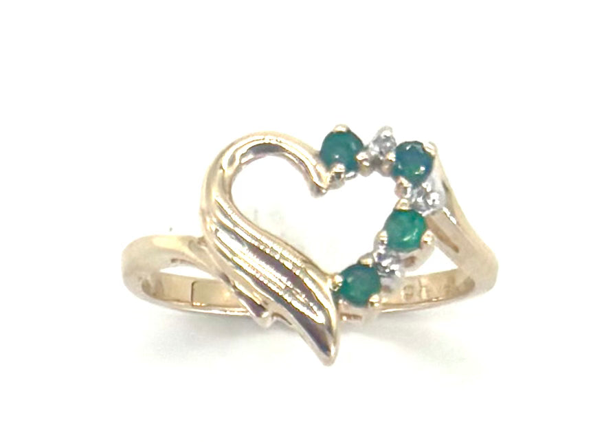 Gold ring with green gemstones on a white background