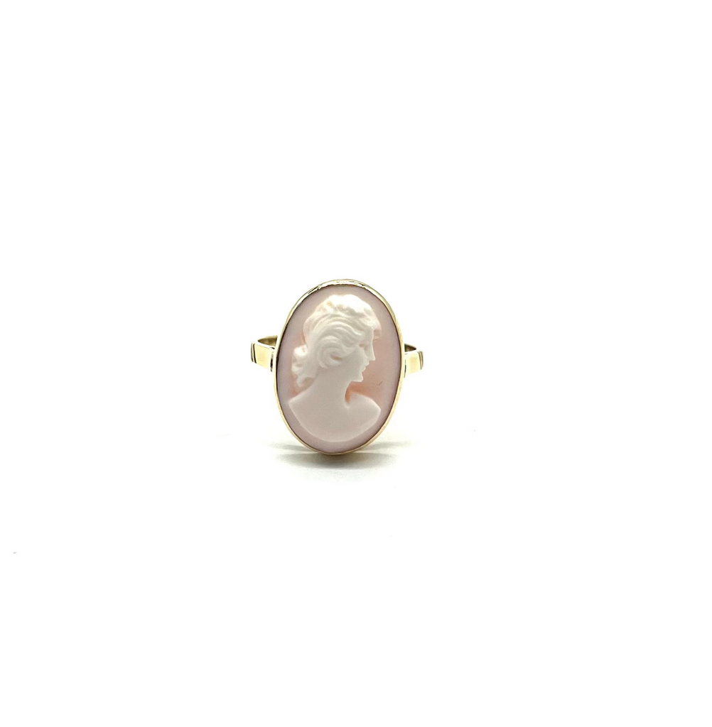 Cameo ring with a white stone and gold setting on a white background