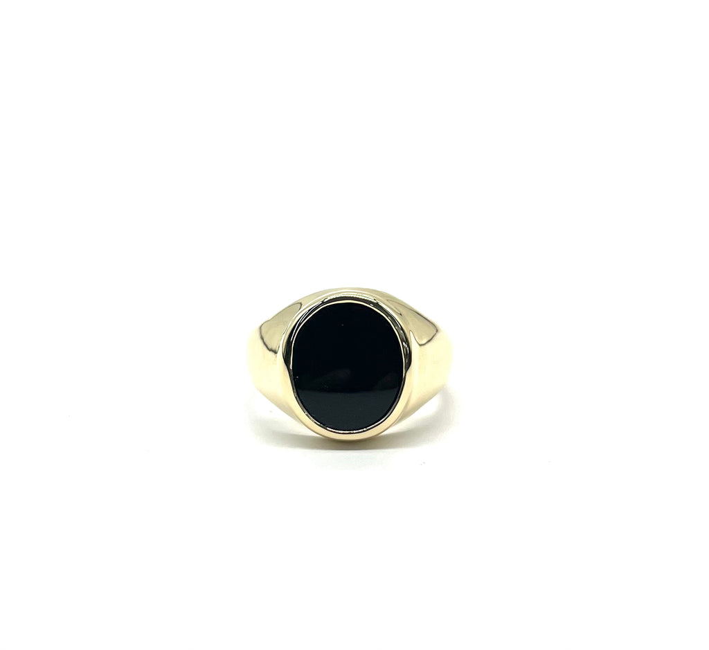 Gold ring with a black stone on a white background
