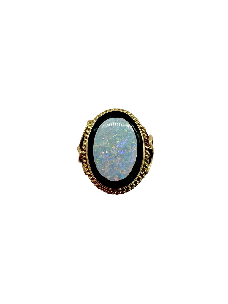 Ring with a blue opal stone and gold band on a white background