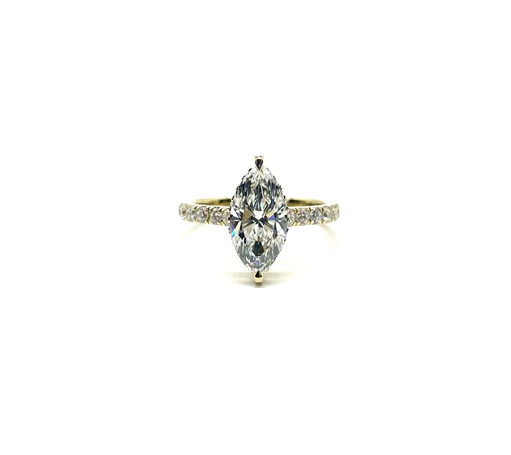 Diamond ring with a pear-shaped center stone on a white background