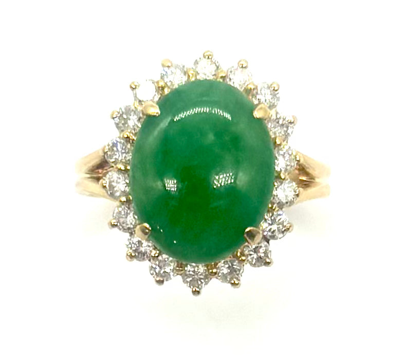 Gold ring with a green gemstone and diamond accents on a white background