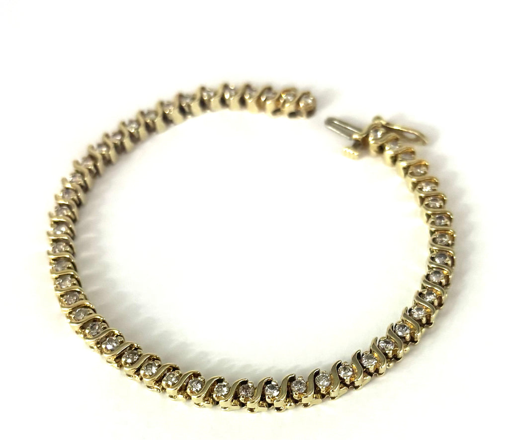 Gold bracelet with clear stones on a white background