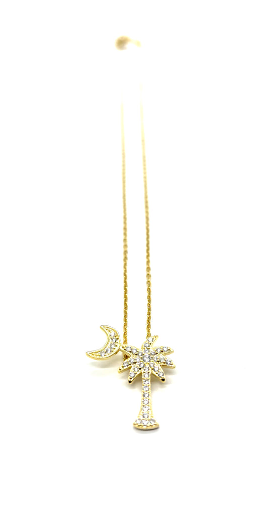 Gold necklace with a palm tree pendant on a white background