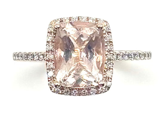 Ring with a pink gemstone and diamond accents on a white background
