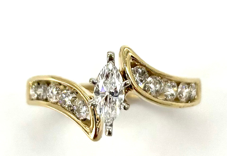 Gold ring with a central diamond and smaller diamonds on a white background