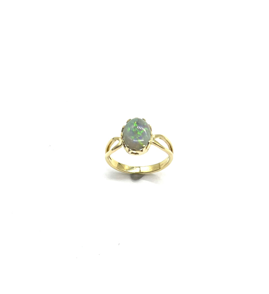 Gold ring with a green gemstone on a white background