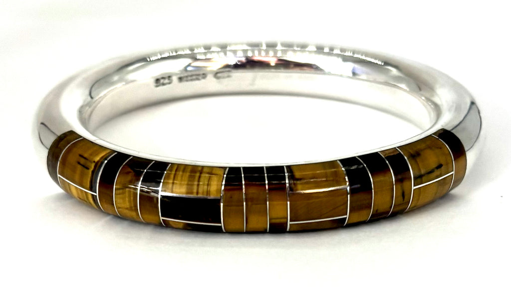 Silver bangle with tiger eye stone inlay on a white background