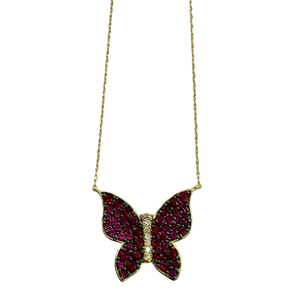 Butterfly-shaped pendant with red stones on a gold chain against a white background