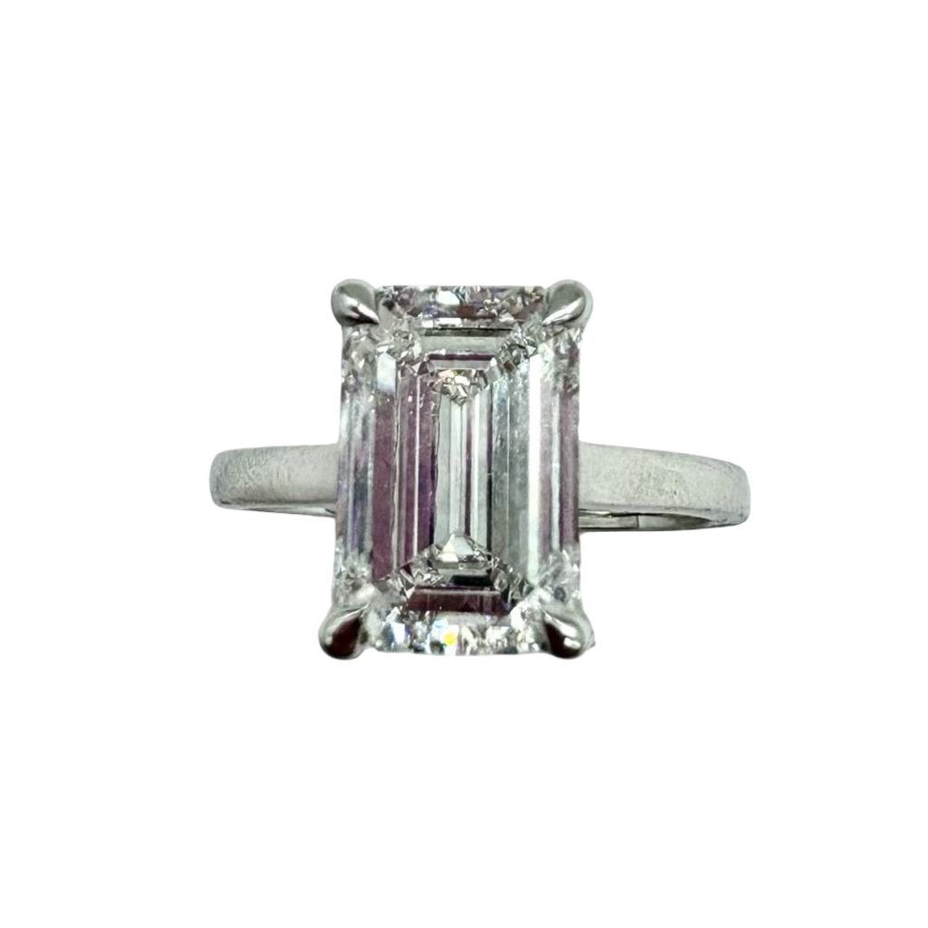 Diamond ring with emerald-cut diamond on a white background