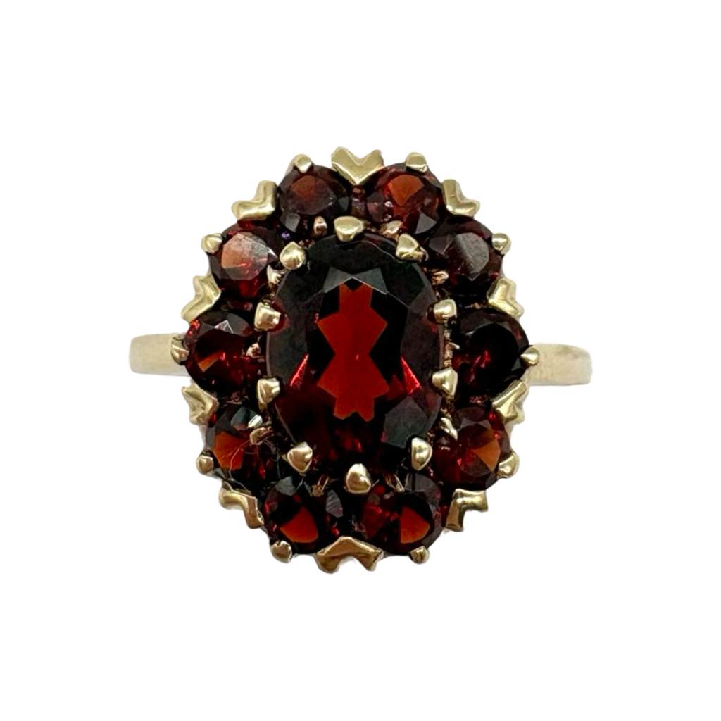 Gold ring with garnet stones on a white background