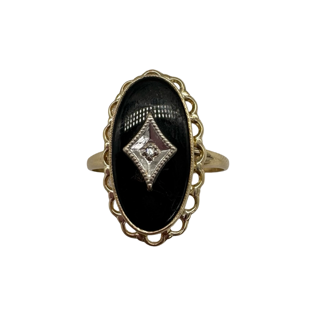 Gold ring with a black oval stone and diamond-shaped center on a white background