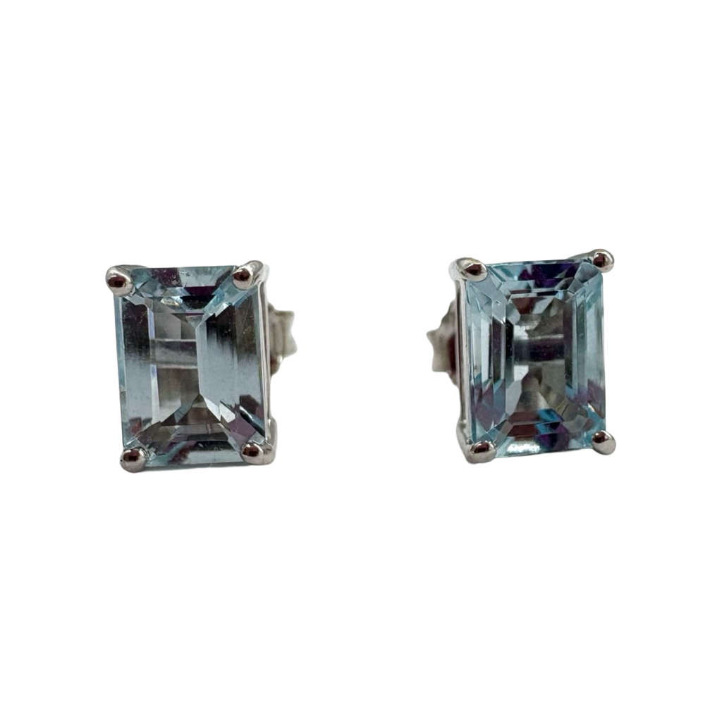 Pair of emerald-cut gemstone stud earrings on a white background