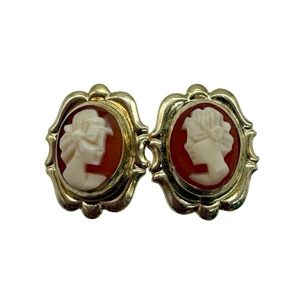 Pair of gold earrings with cameo designs on a white background