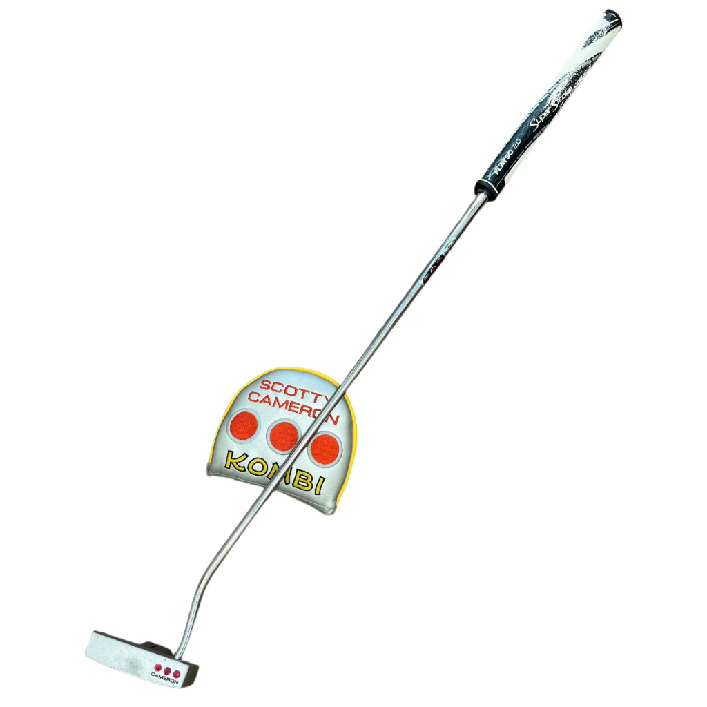 Golf club with a Scotty Cameron putter head on a wooden floor