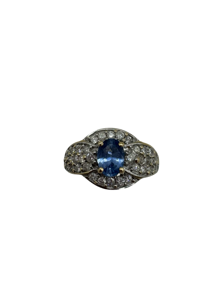 Ring with blue gemstone and diamond accents on a white background