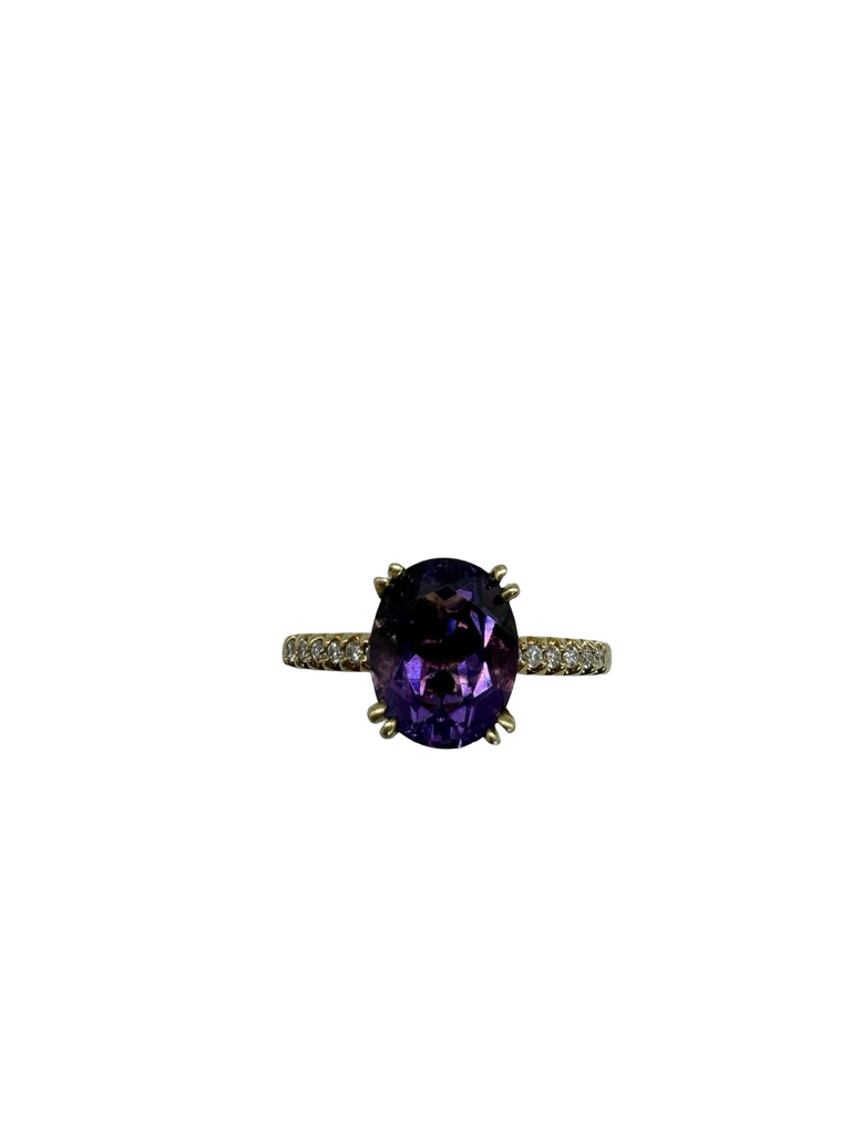 Ring with a purple gemstone on a white background