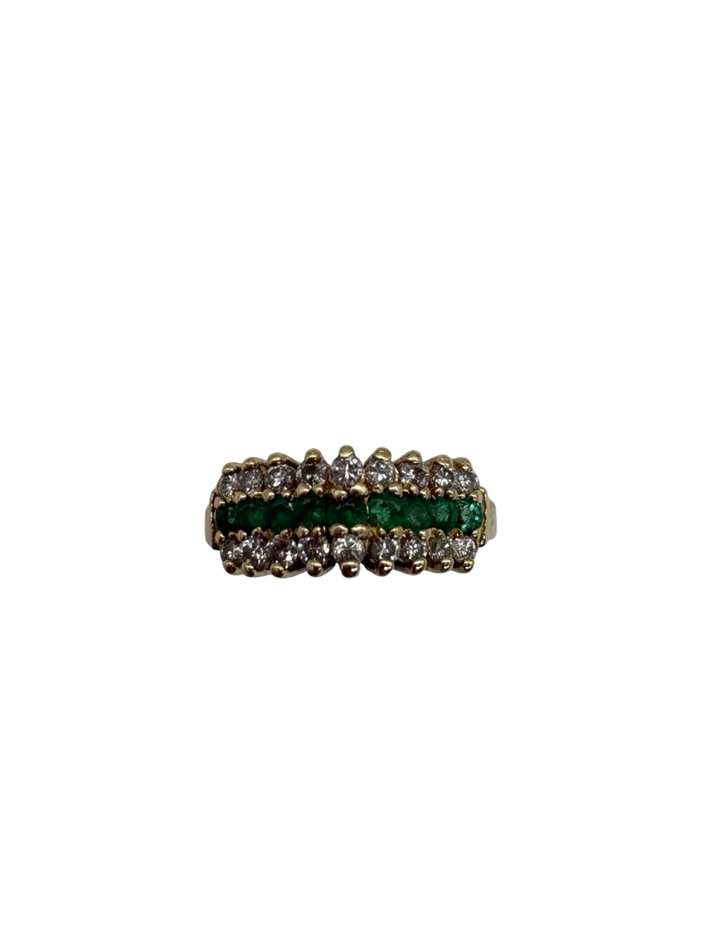 Ring with green gemstones and gold accents on a white background