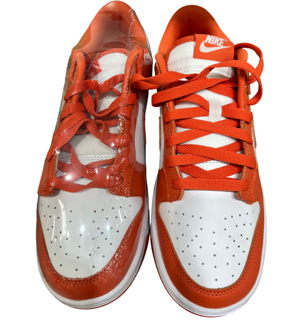 Orange and white sneakers on a concrete floor