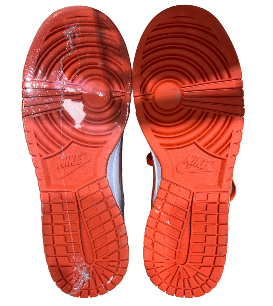 Red Nike shoe soles on a concrete floor