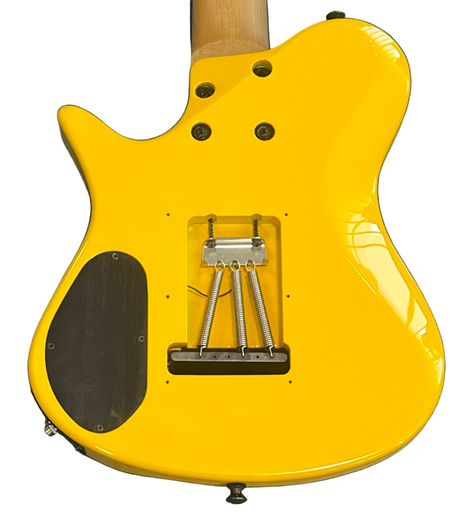 Yellow electric guitar body on a blue surface