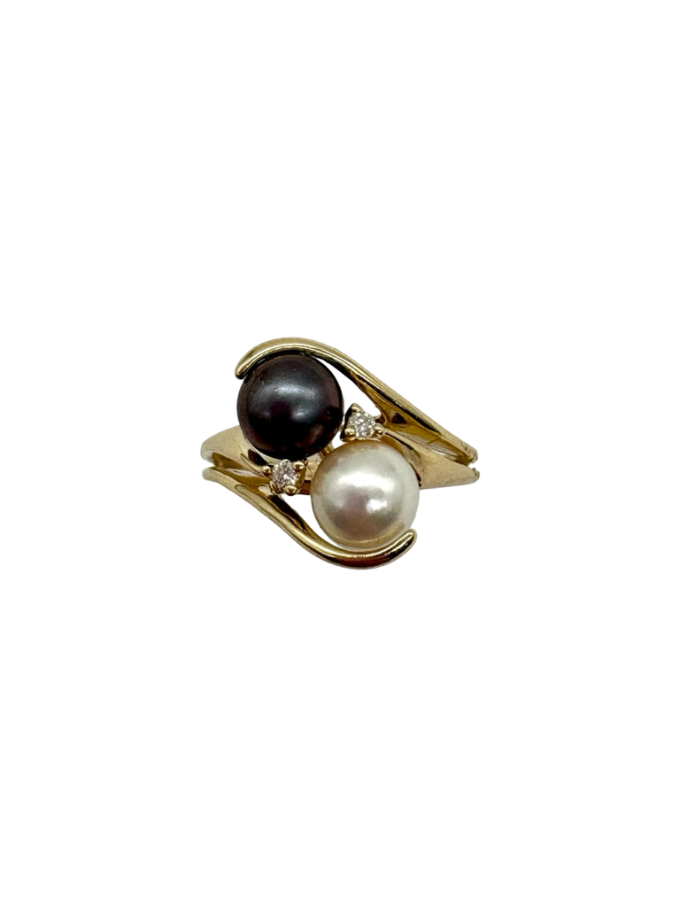 Gold ring with black and white pearls on a white background