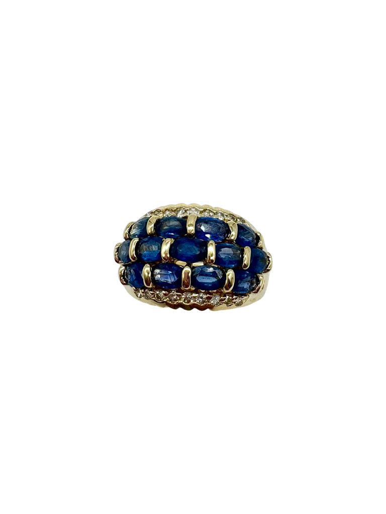 Gold ring with blue gemstones on a white background